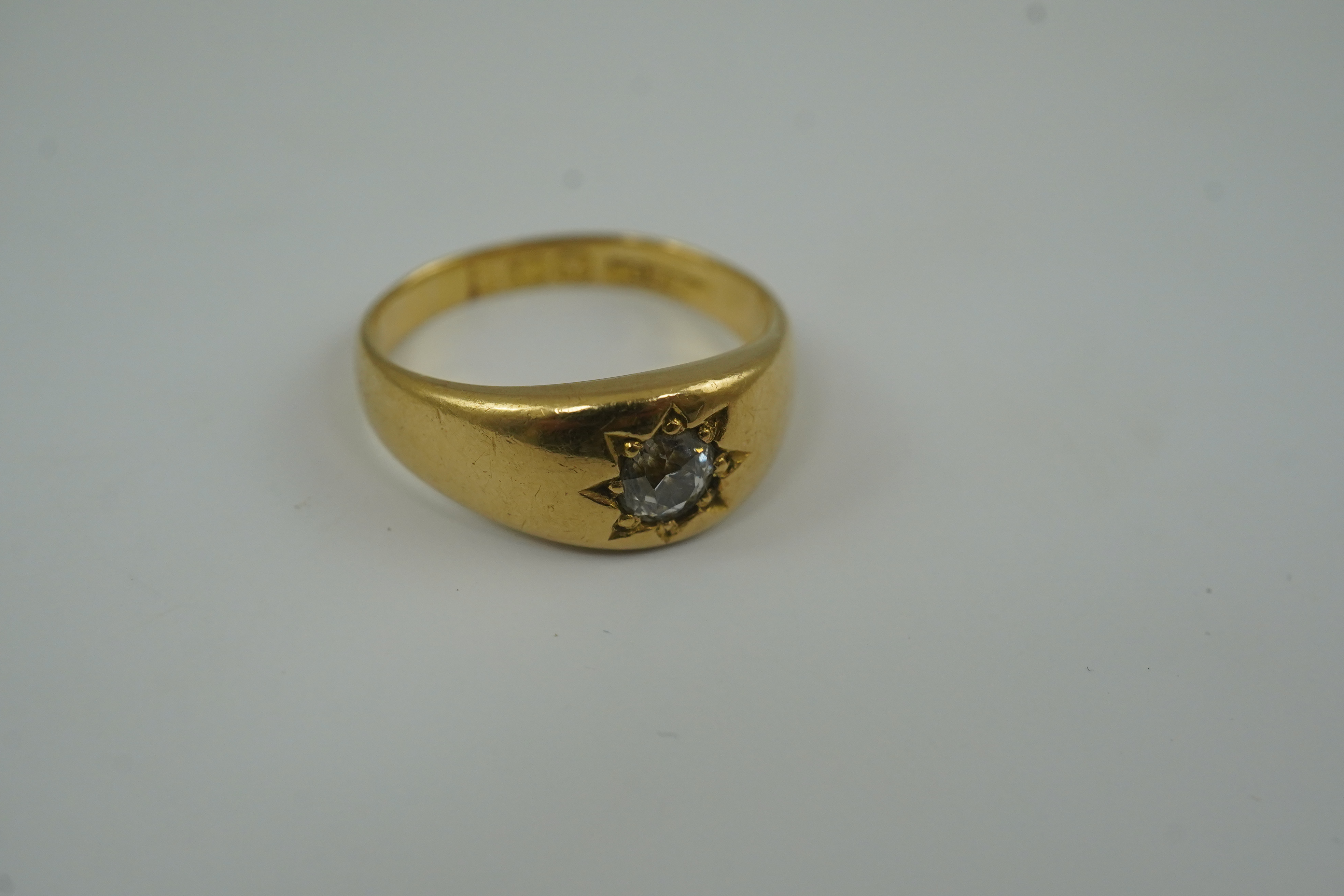 An early 20th century 18ct gold and gypsy set solitaire diamond ring